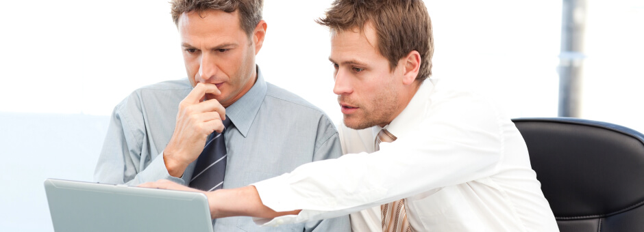 2 men thinking and acting in front of a computer