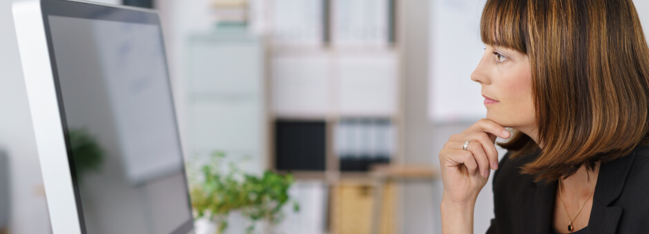 Woman thinking in front of a computer screen