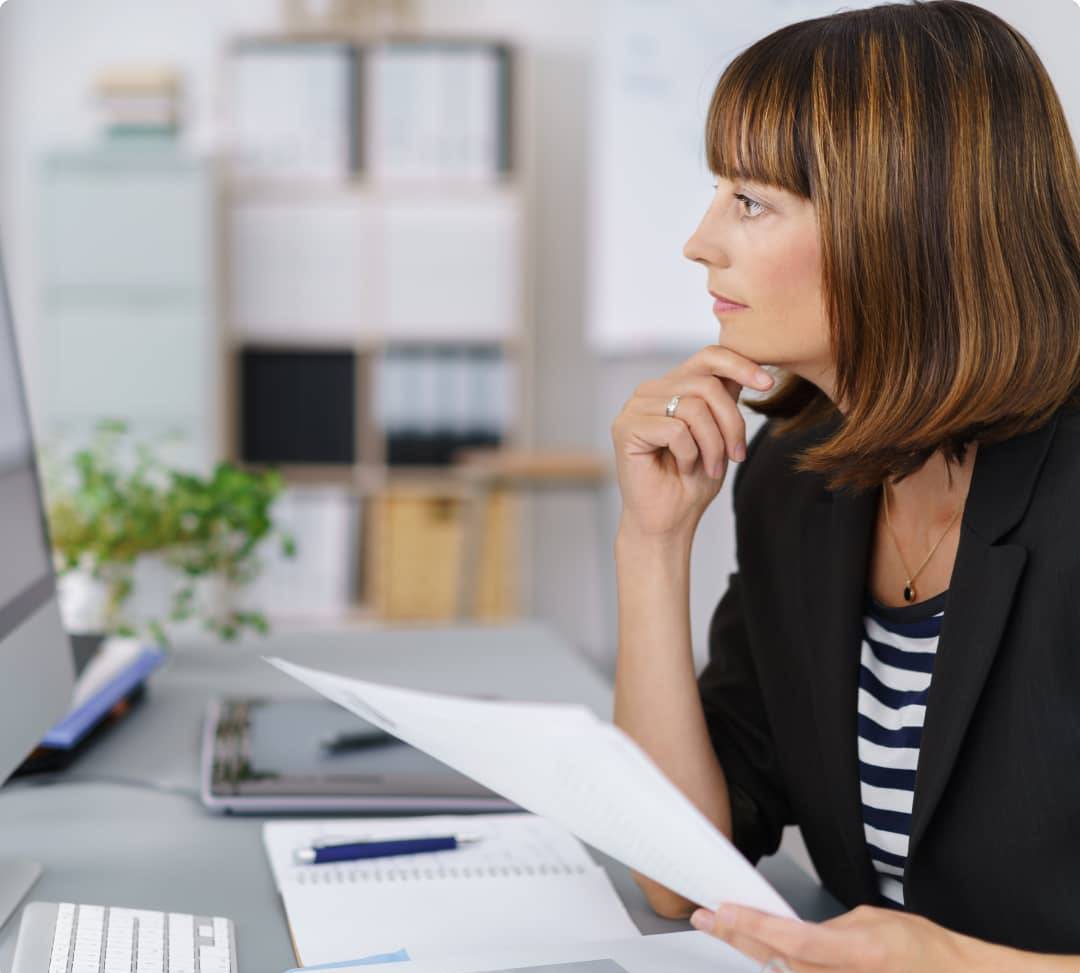 Woman thinking in front of a computer screen